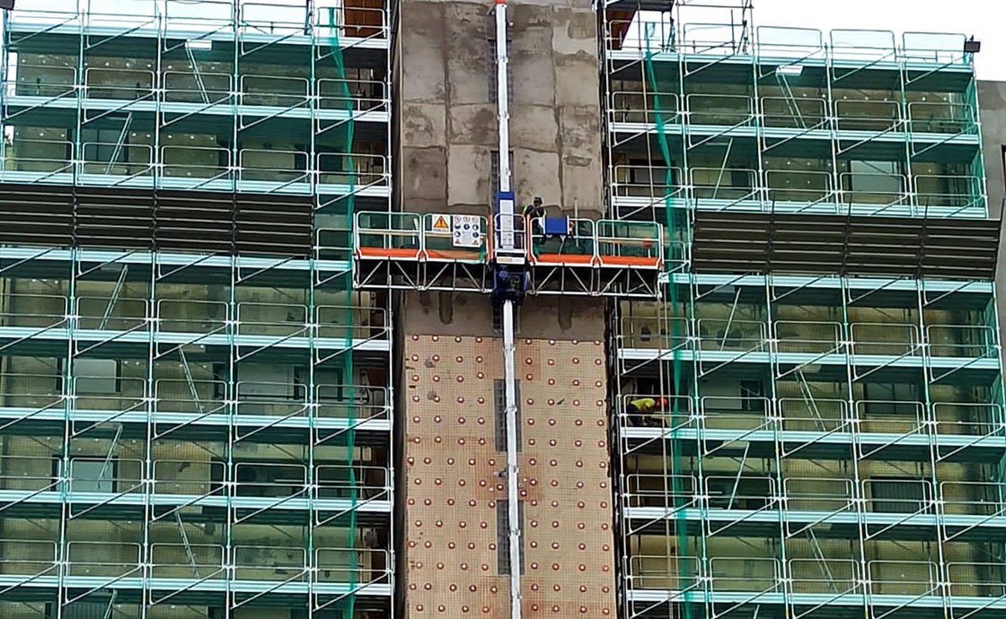 Operai al lavoro all'esterno di un condominio a Taranto nell'ambito degli interventi di Riqualificazione Energetica e Miglioramento Sismico