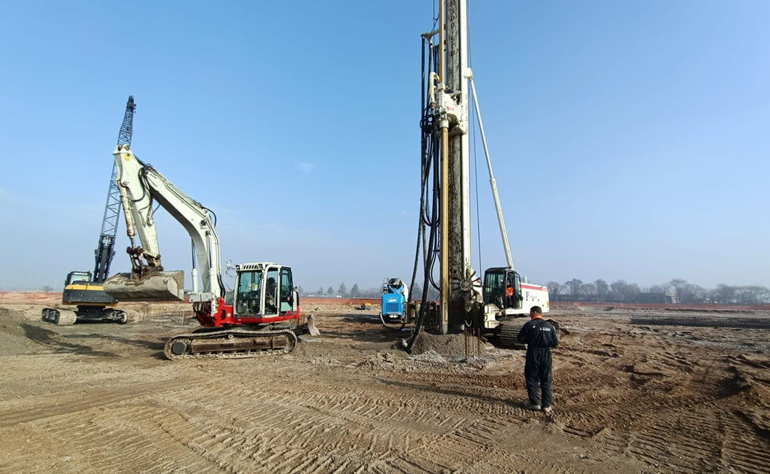 Cantiere con operai e macchinari per realizzazione di hangar di manutenzione, linee di volo, polo tecnologico, centrali elettriche