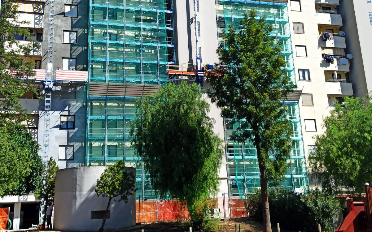 Frontespizio palazzo con operai al lavoro per ristrutturazione con superbonus